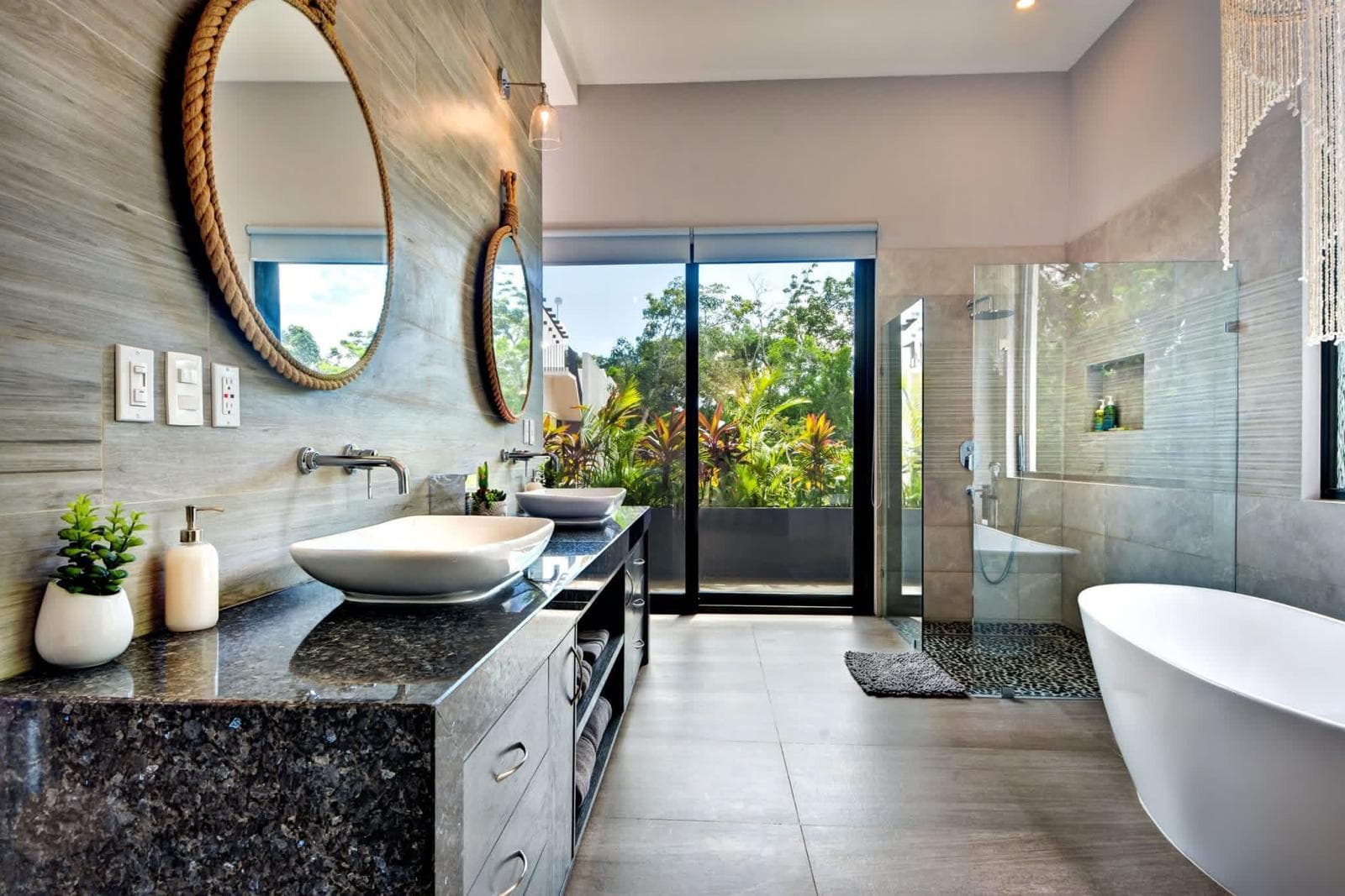 Bathroom with rope mirrors, vessel sinks and a freestanding tub