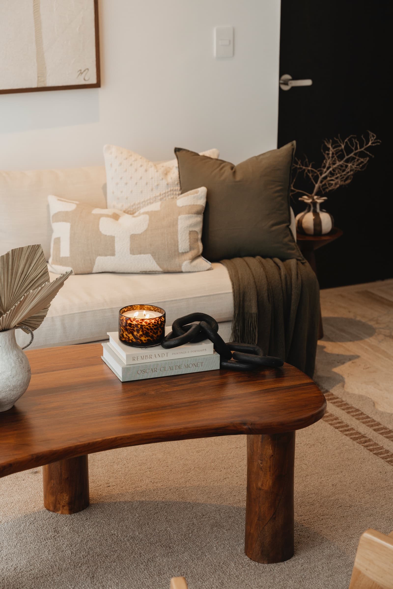 Living room with a walnut coffee table, cream sofa and dried palm styling