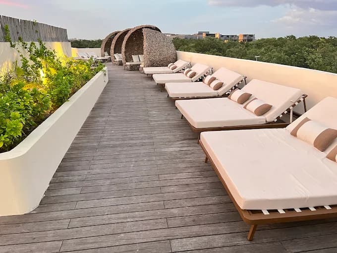 Terraza en azotea con camastros y vista a la selva en Artia Condos