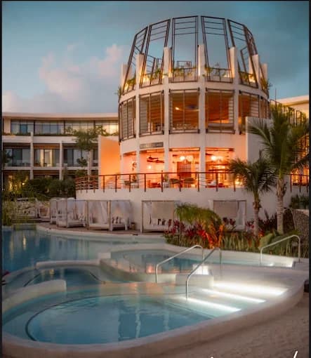 Amenidades de Artia Condos al atardecer con albercas iluminadas