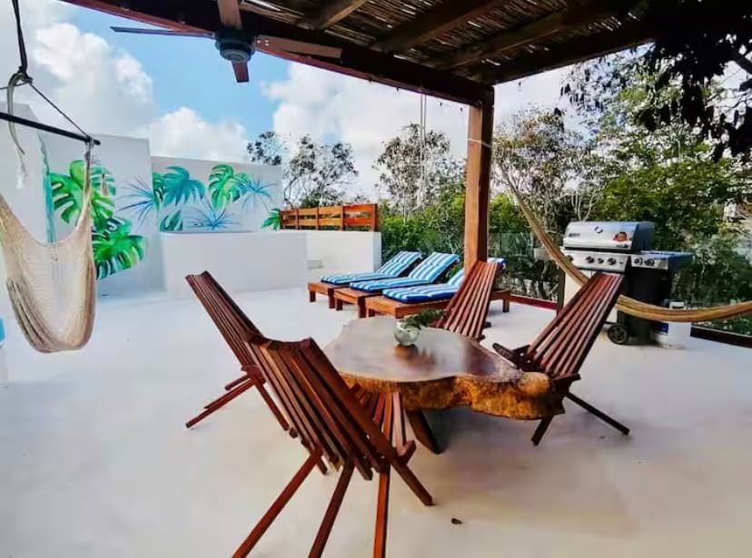 Terraza en azotea con mesa de comedor live-edge